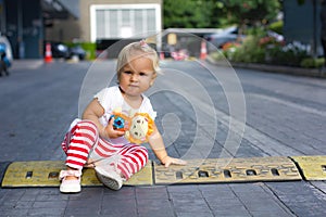 Cute toddler sit on road hump