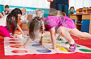 Cute toddlers playing in twister game photo