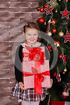 Cute toothsome girl wearing stylish casual clothes happy enjoy christmas time holidays close to new year green pine tree decorated