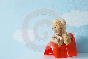 Cute toy sitting on the potty
