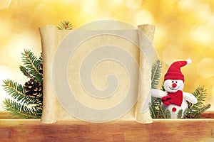 Cute toy snowman on golden background with scroll