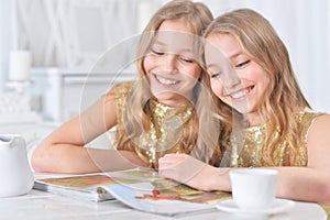Cute twin sisters with modern magazine photo