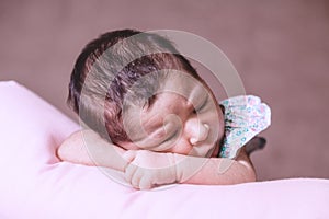 Cute two weeks old newborn baby girl sleeping peacefully