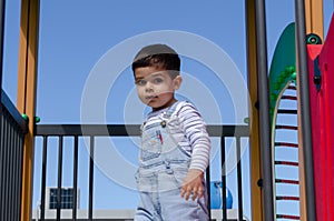 Cute two years old boy playig in the children playground outdoors on the playhouse