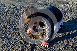 Cute two years old toddler playing with water on the stone path