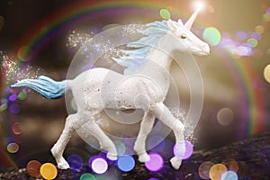 Cute unicorn walking in the sparkling rainbow forest