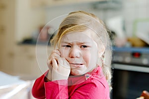 Cute upset unhappy toddler girl crying. Angry emotional child shouting. Portrait of kid with tears.