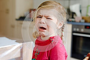 Cute upset unhappy toddler girl crying. Angry emotional child shouting. Portrait of kid with tears.