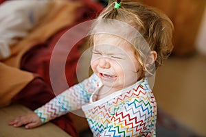 Cute upset unhappy toddler girl crying. Angry emotional child shouting. Portrait of kid with tears indoors