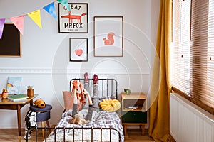 Cute vintage style posters on white wall of trendy bedroom for child