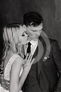 Cute wedding couple in the interior of a classic studio decorated. They kiss and hug each other