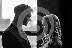 Cute wedding couple in the interior of a classic studio decorated. They kiss and hug each other