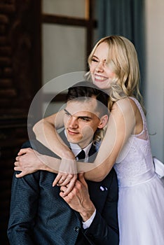 Cute wedding couple in the interior of a classic studio decorated. They kiss and hug each other