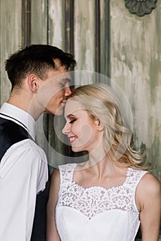 Cute wedding couple in the interior of a classic studio decorated. They kiss and hug each other