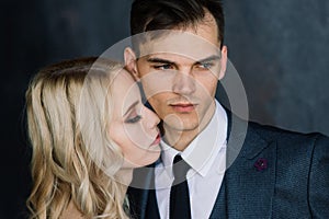 Cute wedding couple in the interior of a classic studio decorated. They kiss and hug each other.