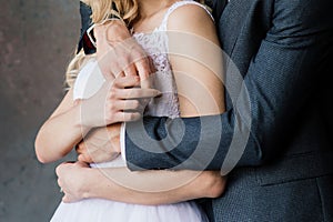 Cute wedding couple in the interior of a classic studio decorated. They kiss and hug each other.