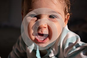 Cute white 9-month baby girl smile. Dark black background.