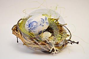 A cute wicker nest with a stingy egg and moss. Easter decoration. Moss. Quail egg photo