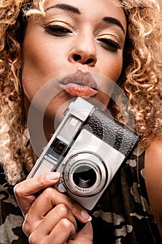 Cute Woman Blowing a Kiss While Holding a Retro Camera
