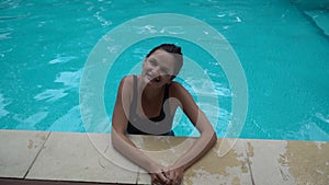 Cute woman enjoys water in swimming pool