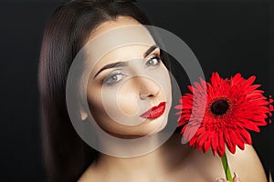 Cute woman Europeans, light make-up on her face in her hands and her hair pink gladiolus flowers. Female portrait. Woman with flow