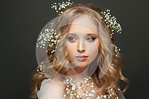 Cute woman with flowers on gray background