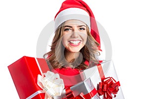 Cute woman holding a Christmas and New Year gifts. Christmas girl in santa hat with boxes.