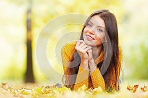 Cute woman laying in autumn park