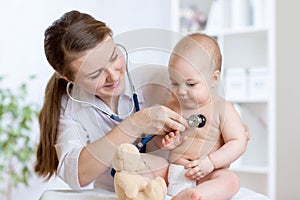 Cute woman pediatrician examining of baby kid with stethoscope