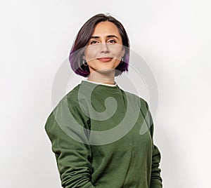 Cute woman with short dark hair is happy, smiling widely. Green sweater. White background, isolated