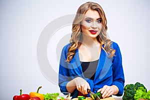 Cute woman slices cucumber for diet salad.