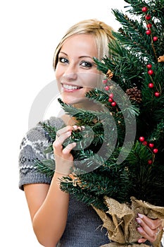 Cute woman smiling and holding a christmastree photo
