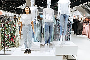 Cute woman standing like mannequin, clothing store