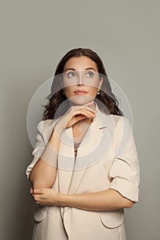 Cute woman in suit on gray background