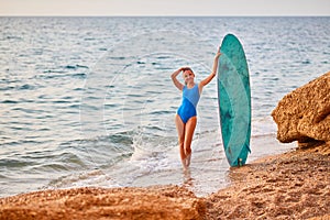 Cute woman with surfboard on nature landscape background. Beach, adventure time and summer holiday concept. Copy space