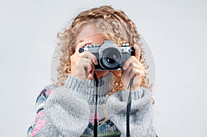 Cute woman taking a photo with a camera on a white background