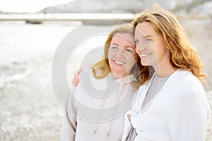 Cute woman tenderly hugs her mature mother on Mother\'s Day