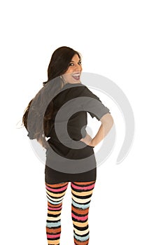 Cute woman wearing colorful leggings looking over her shoulder