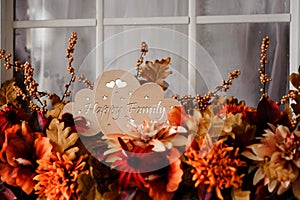 Cute wooden plaque with the inscription happy family among flowers