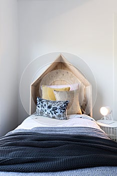 Cute wooden tent style wooden bedhead in a styled children`s bed
