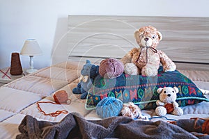 Cute wool teddy bear is lying in the bed