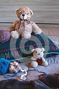 Cute wool teddy bear is lying in the bed
