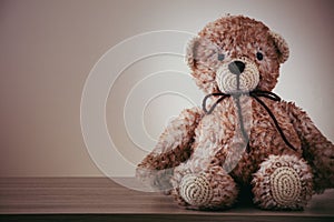 Cute wool teddy bear is lying on the table