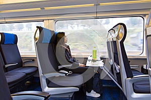 Cute young asian female tourists sitting on the express train