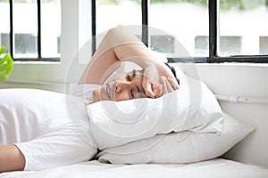 Cute young Asian man sleeping on bed in the morning resting peacefully in comfortable bed, lying with closed eyes