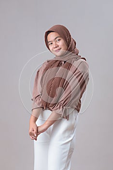 Cute young Asian muslim woman in hijab light clothes posing  on gray background