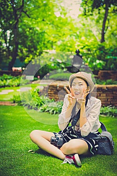 Cute young Asian Thai girl with fashionable clothes is sitting