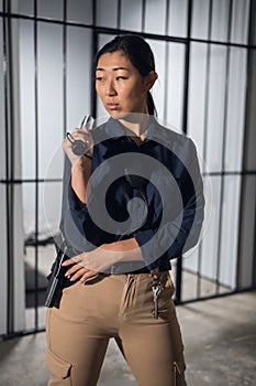 Cute young asian woman works as a prison guard, posing in uniform