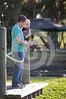 Cute Young Boy and Dad Fishing on the Lake Dock