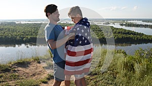 Cute young boy and his father holding aloft the American flag